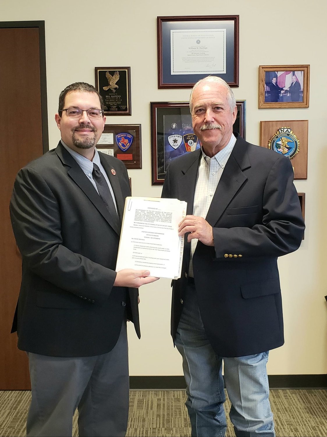 Katy's Mayor Pro Tem Chris Harris (left) and Mayor Bill Hastings (right) pose with a copy of the city's new ordinance which restricts where registered sex offenders may live or visit in the city.